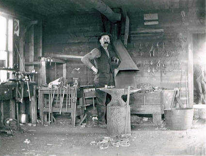 Victorian blacksmith in his blacksmithing workshop, surrounding by tools of the blacksmithing trade